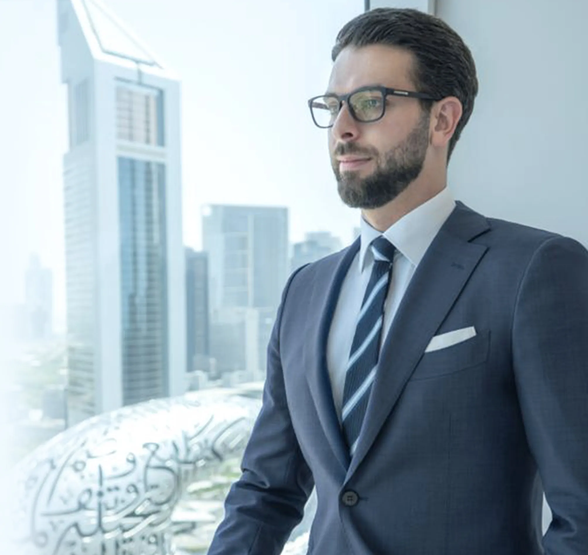 Dr. Mohammed Naji in a navy suit by a window overlooking Dubai